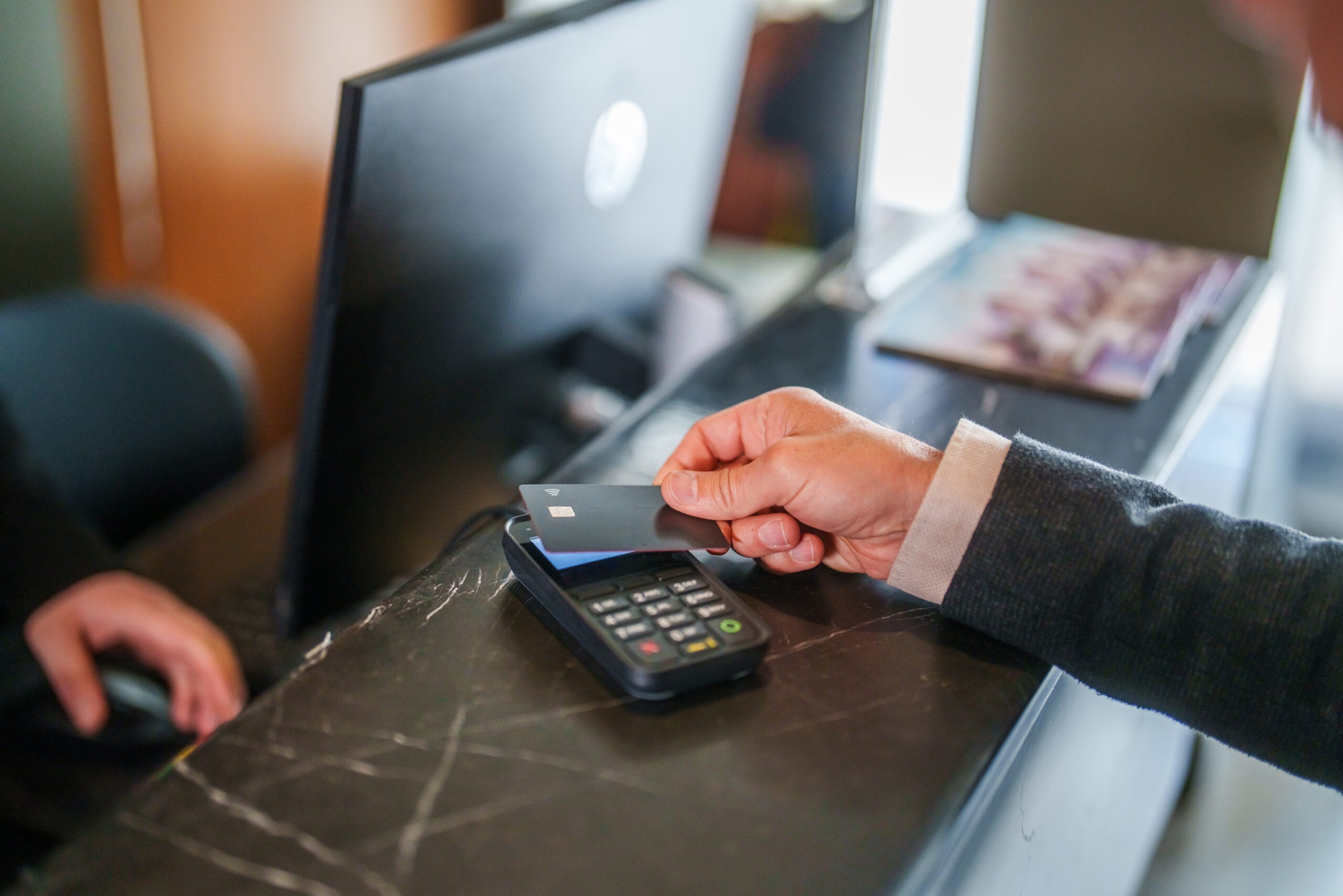 Man pays at hotel reception with a credit card