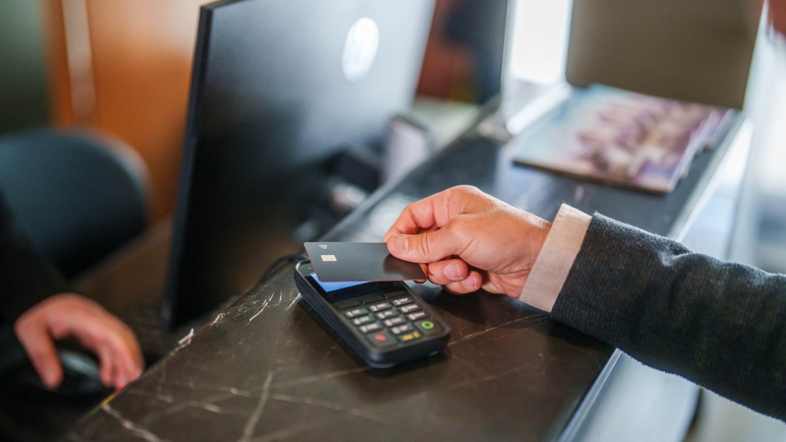 Man pays at hotel reception with a credit card