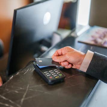 Man pays at hotel reception with a credit card