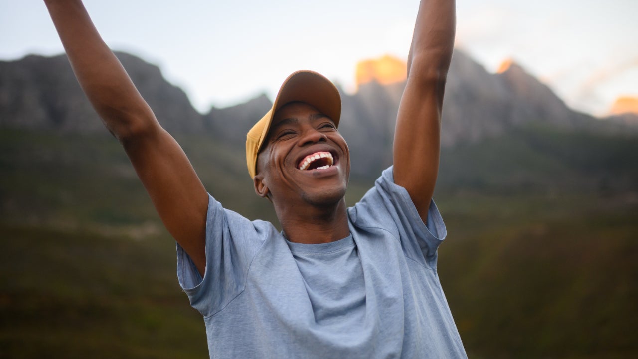 Triumphant man thrusts his fists into the air with joy
