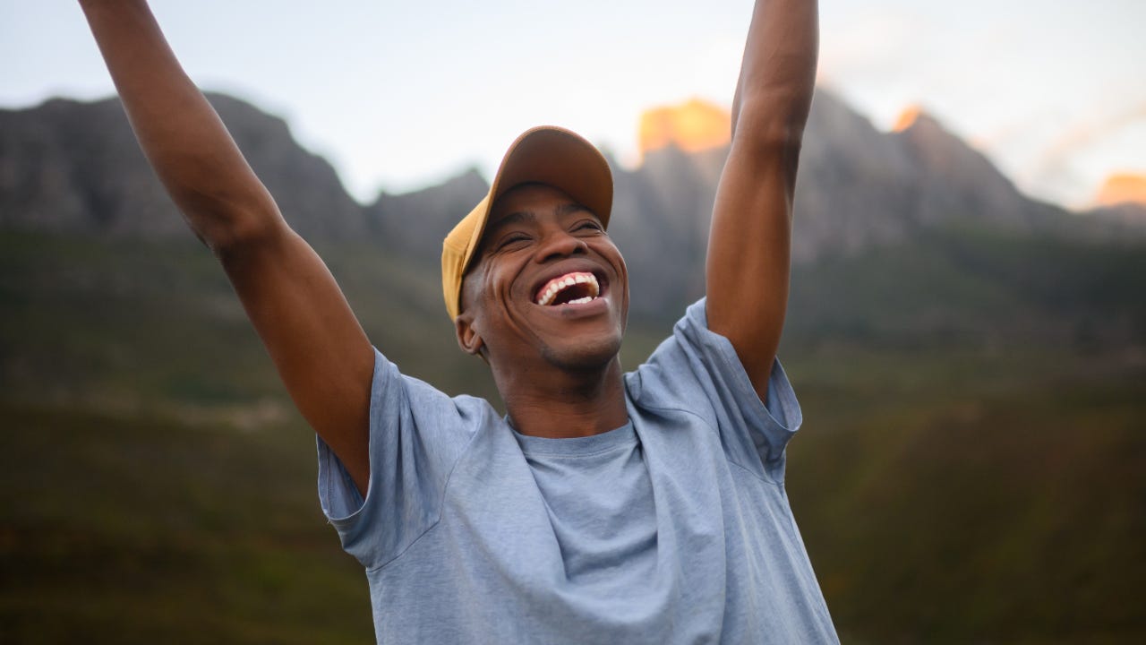 Triumphant man thrusts his fists into the air with joy