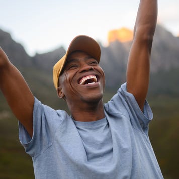 Triumphant man thrusts his fists into the air with joy