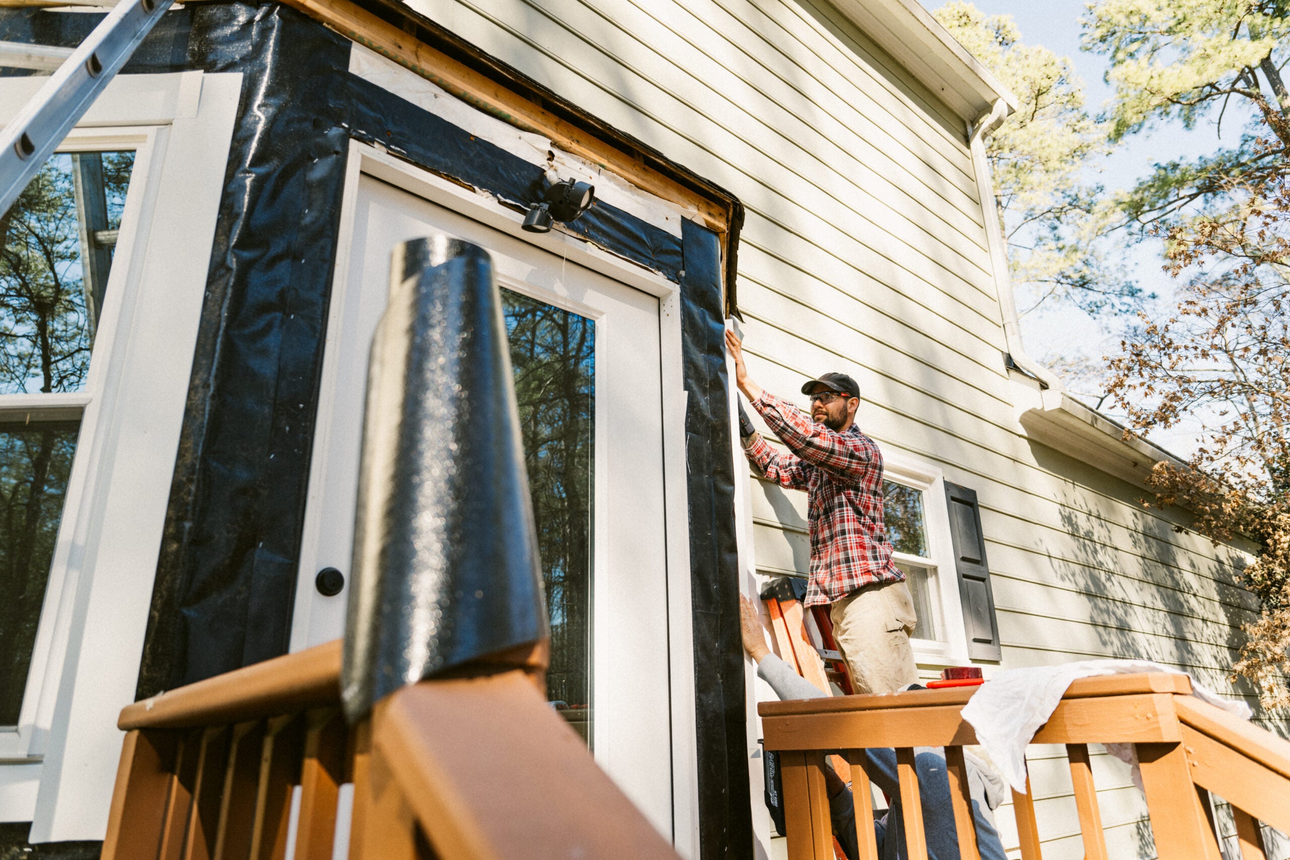 Person repairing home siding
