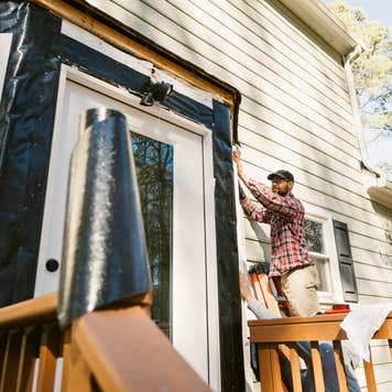 Person repairing home siding