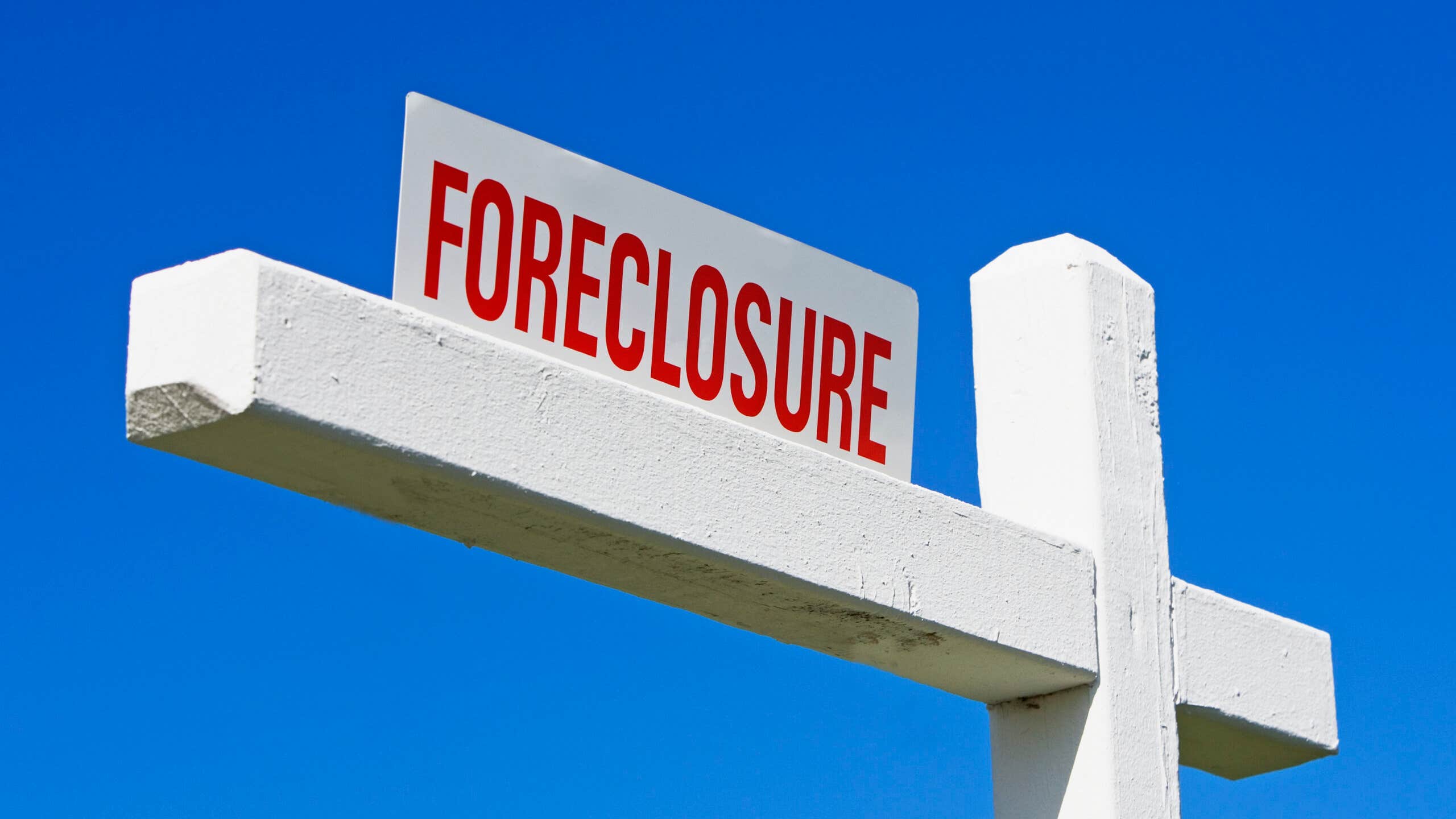 A Floreclosure sign against a blue sky backdrop.