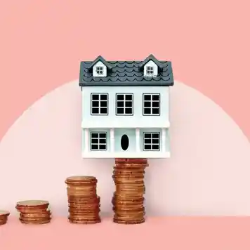 house balanced on stack of coins, pink background, photo illustration