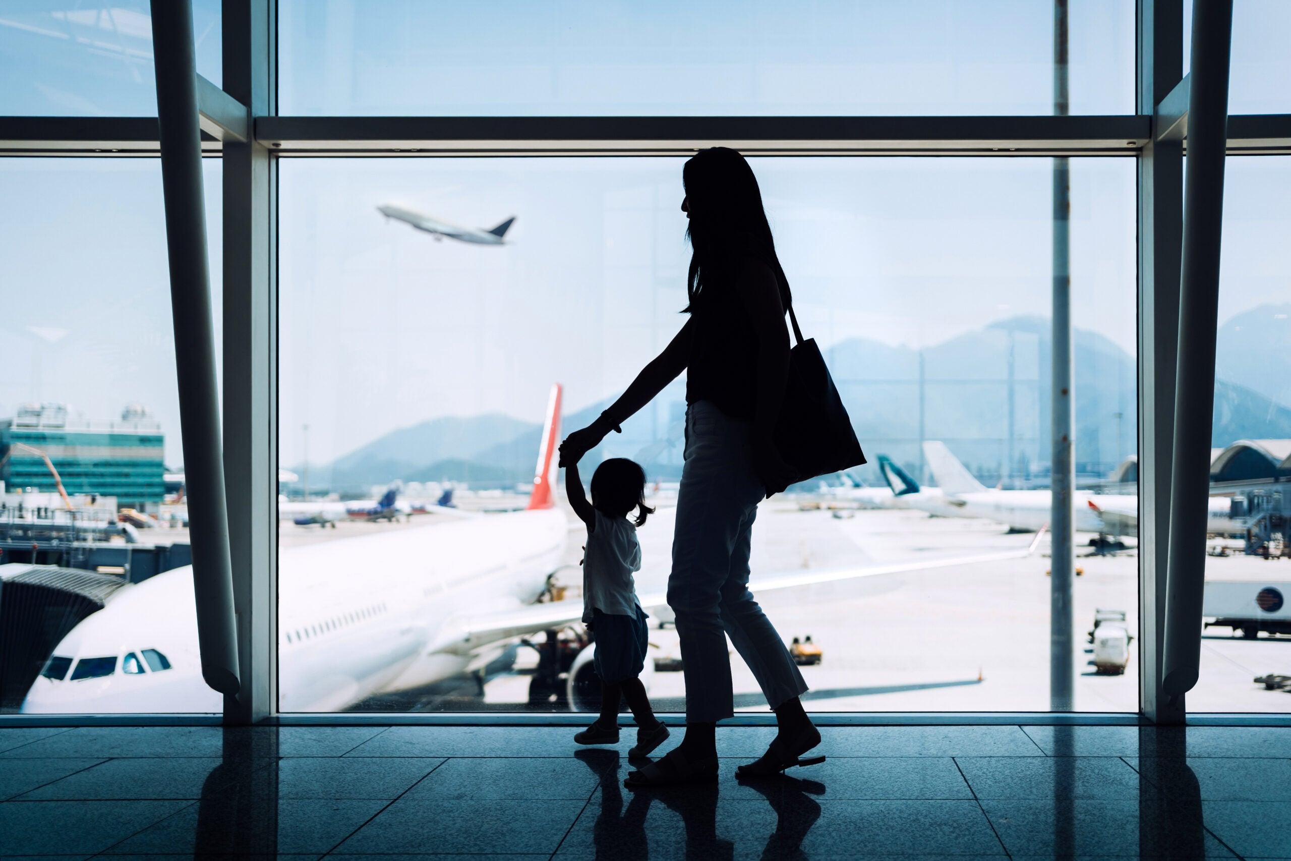 Silhouette of mother and daughter at an airport