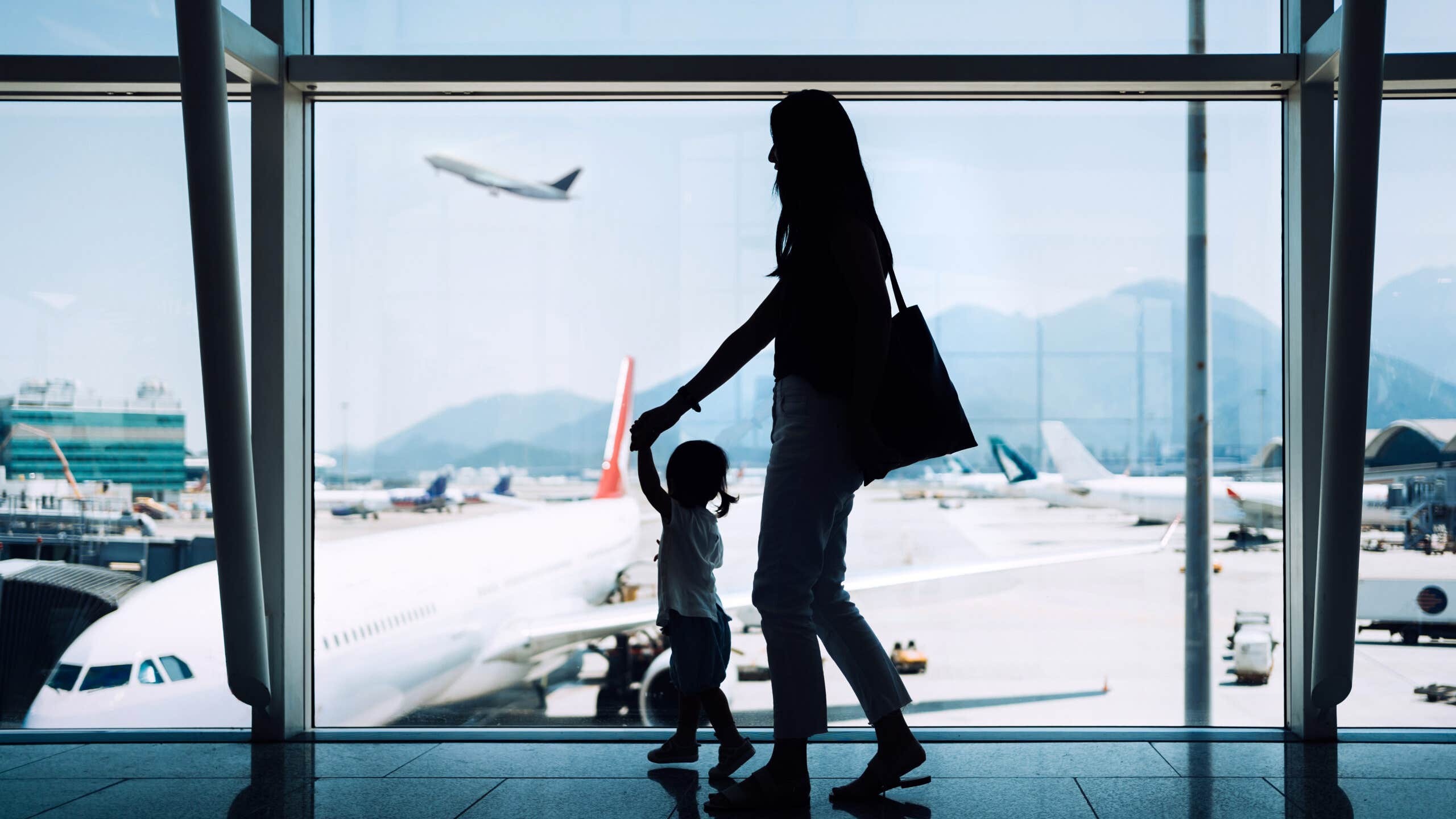 Silhouette of mother and daughter at an airport