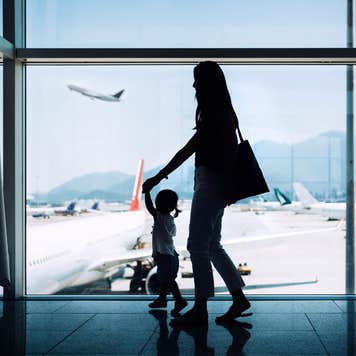 Silhouette of mother and daughter at an airport