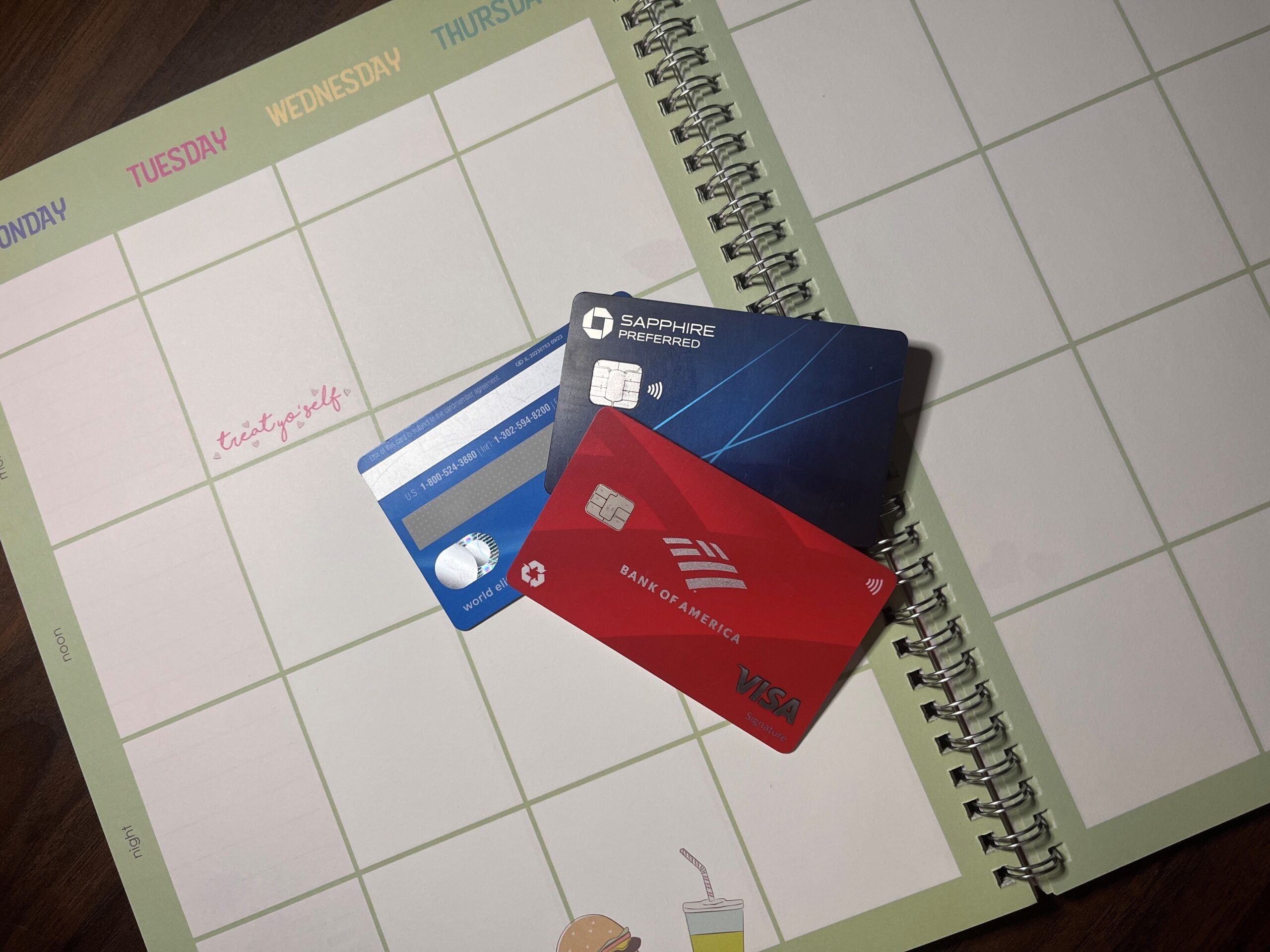 Three credit cards laying on an open planner