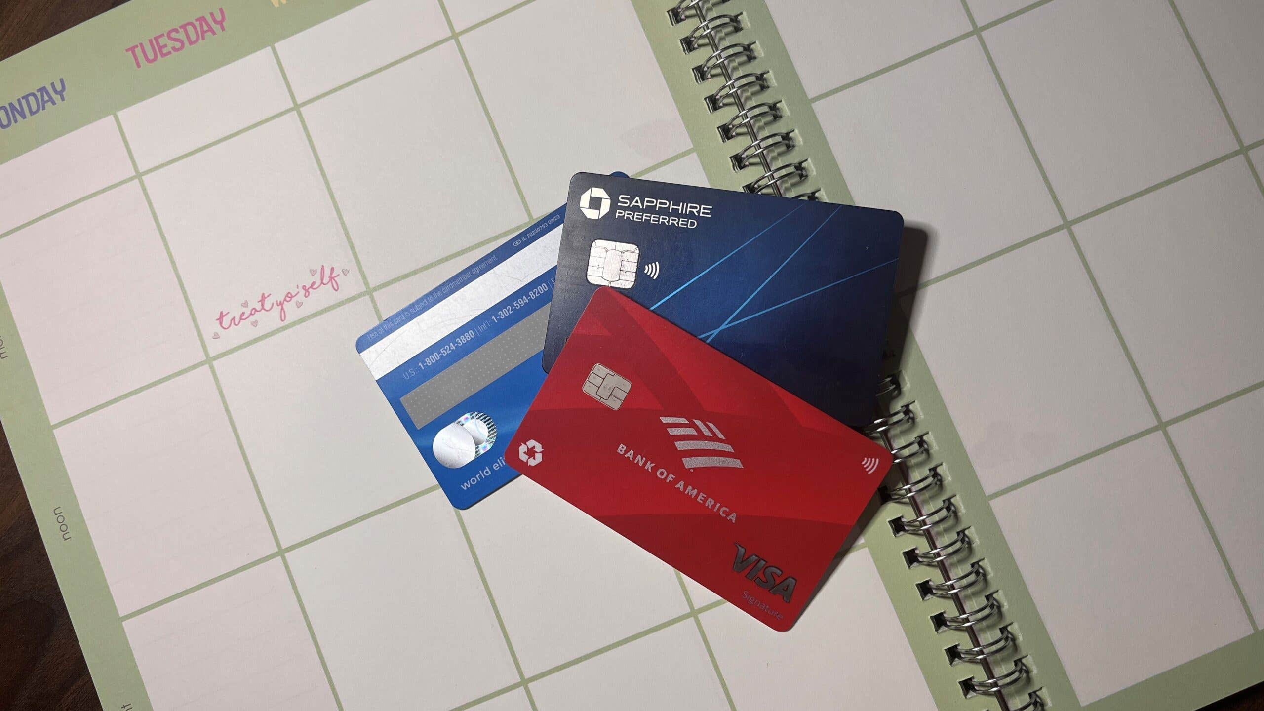 Three credit cards laying on an open planner