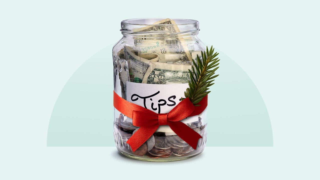 A tip jar with a red ribbon and sprig of pine tied to it.
