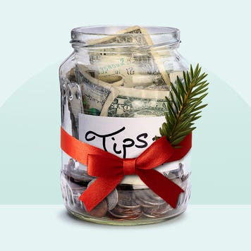 A tip jar with a red ribbon and sprig of pine tied to it.