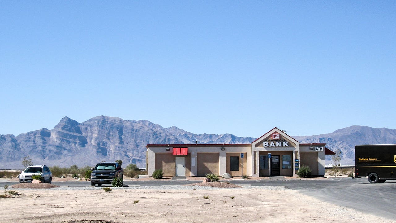 An image of a rural bank building set in front of a mountainous landscape