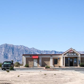 An image of a rural bank building set in front of a mountainous landscape