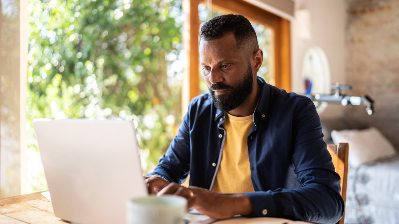 Mature man using laptop working at home.