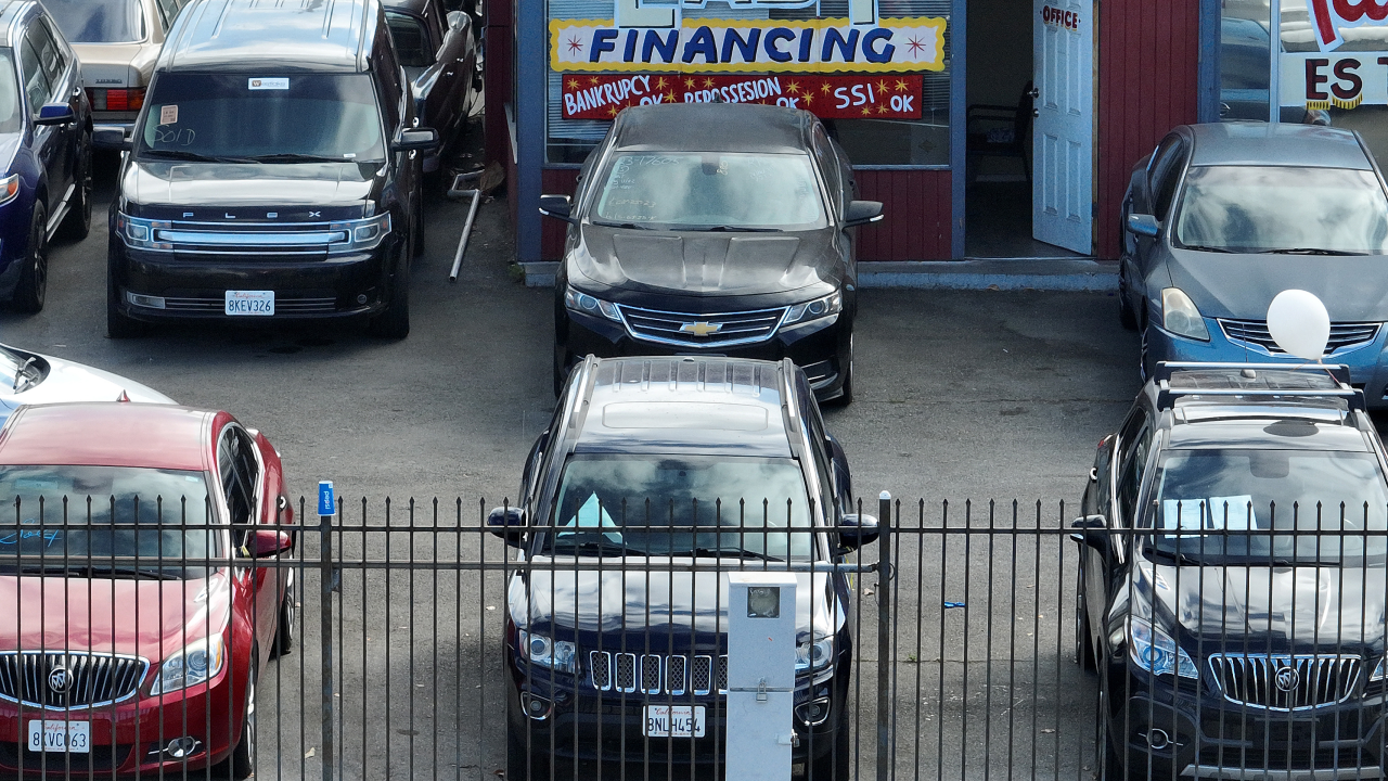 A used car lot promotes easy financing in its storefront.