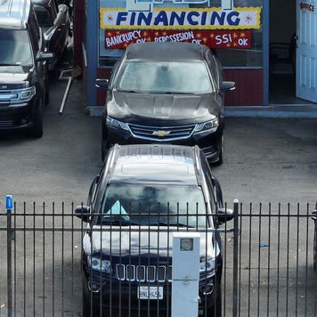 A used car lot promotes easy financing in its storefront.