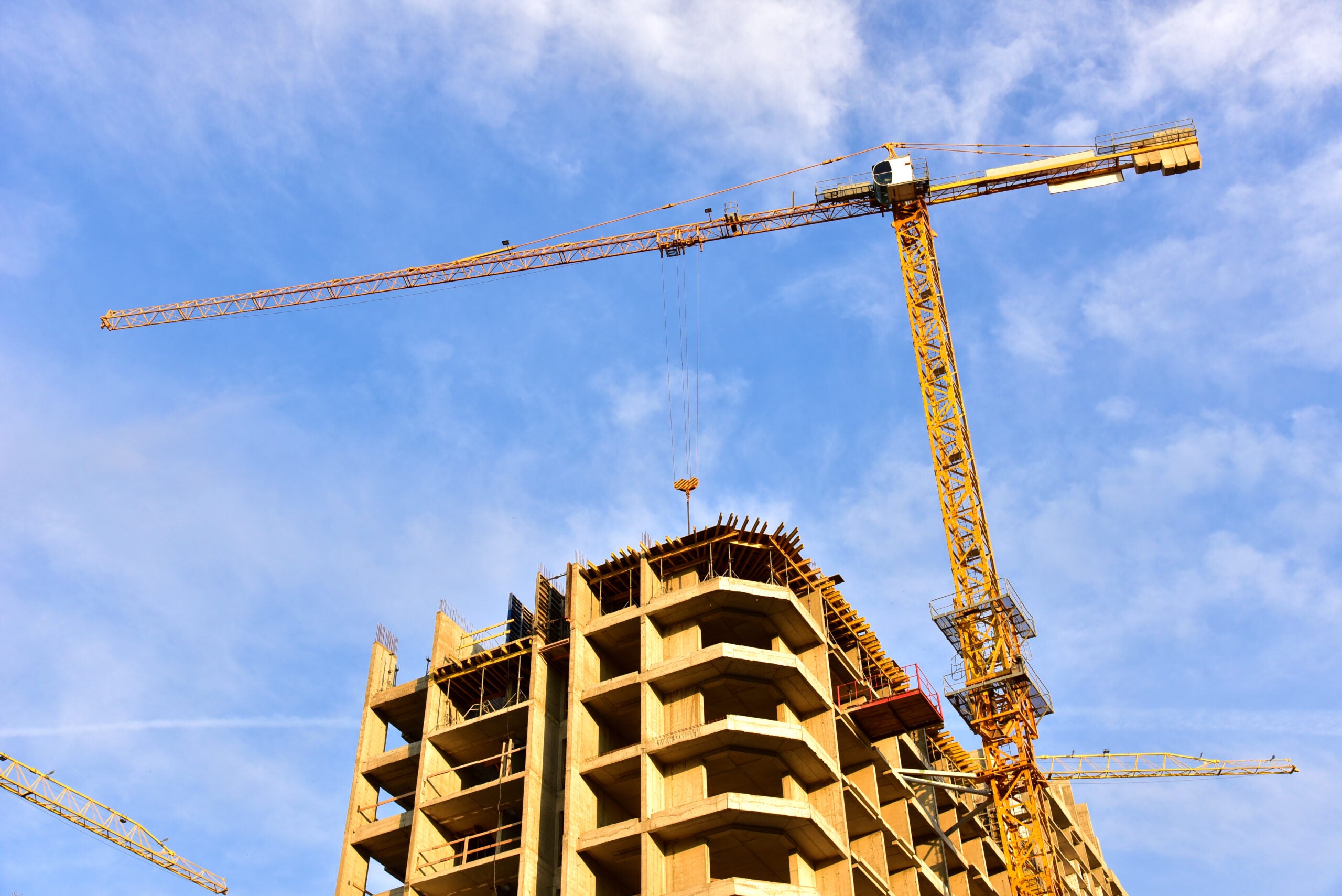 Construction crane stands above building in progress