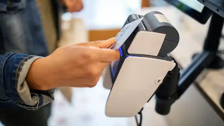 Person using credit card for contactless payment at checkout